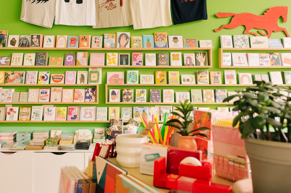 Image of Gift Horse Store in Nashville, TN. Green wall in back with many colorful bright greeting cards pictured in rows